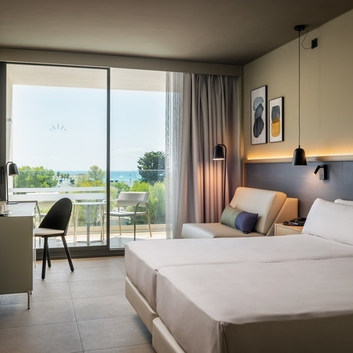 a hotel room with two beds a desk and a balcony