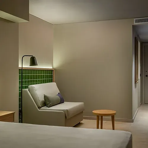 Modernes Hotelzimmer mit Bett, Sessel und Tür, Estival Maramar | Estival Group | Tarragona | Offizielle Website