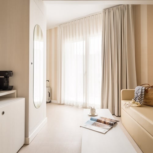 una habitación de hotel con un sofá y una mesa