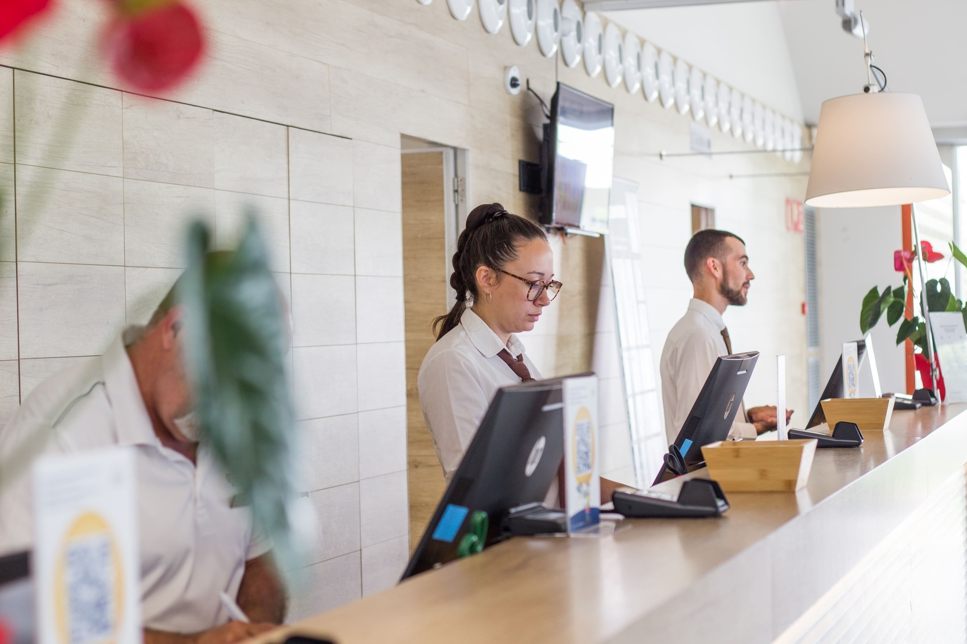 a man and a woman are at a hotel reception desk