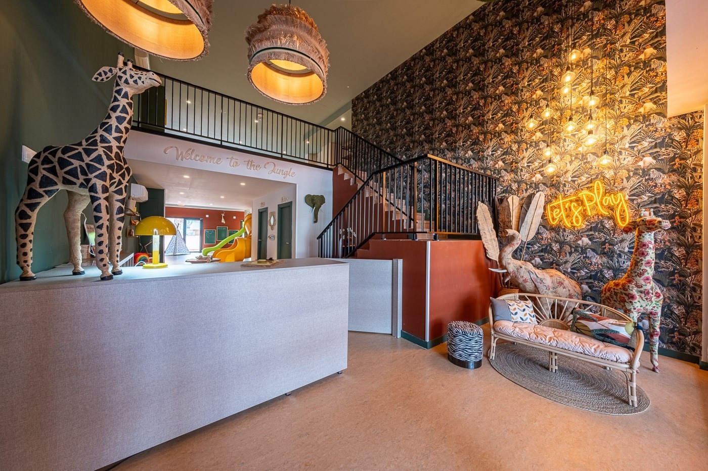 two little girls peeking out of a colorful playground structure