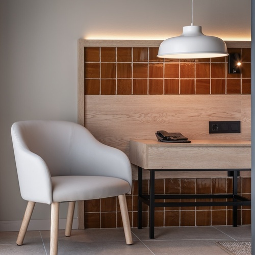 a chair sits next to a desk with a phone on it