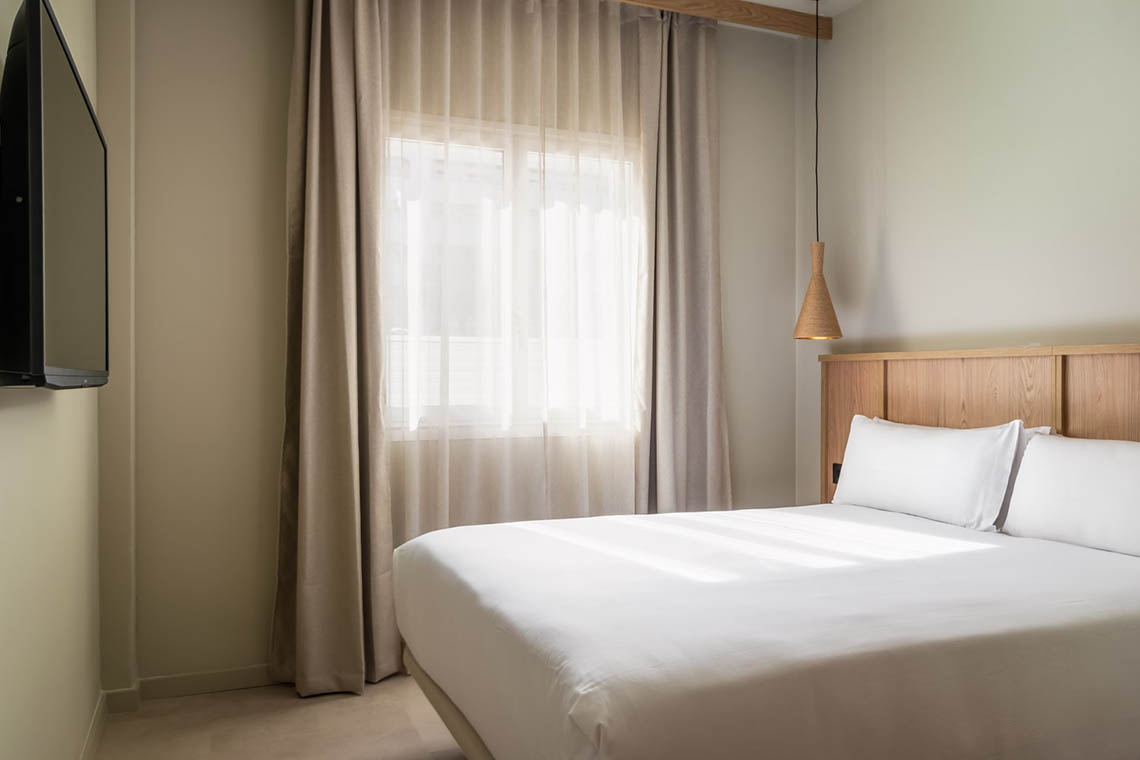 Habitació d'hotel moderna amb llit queen-size, ideal per a ESTIVAL: Corporatiu.