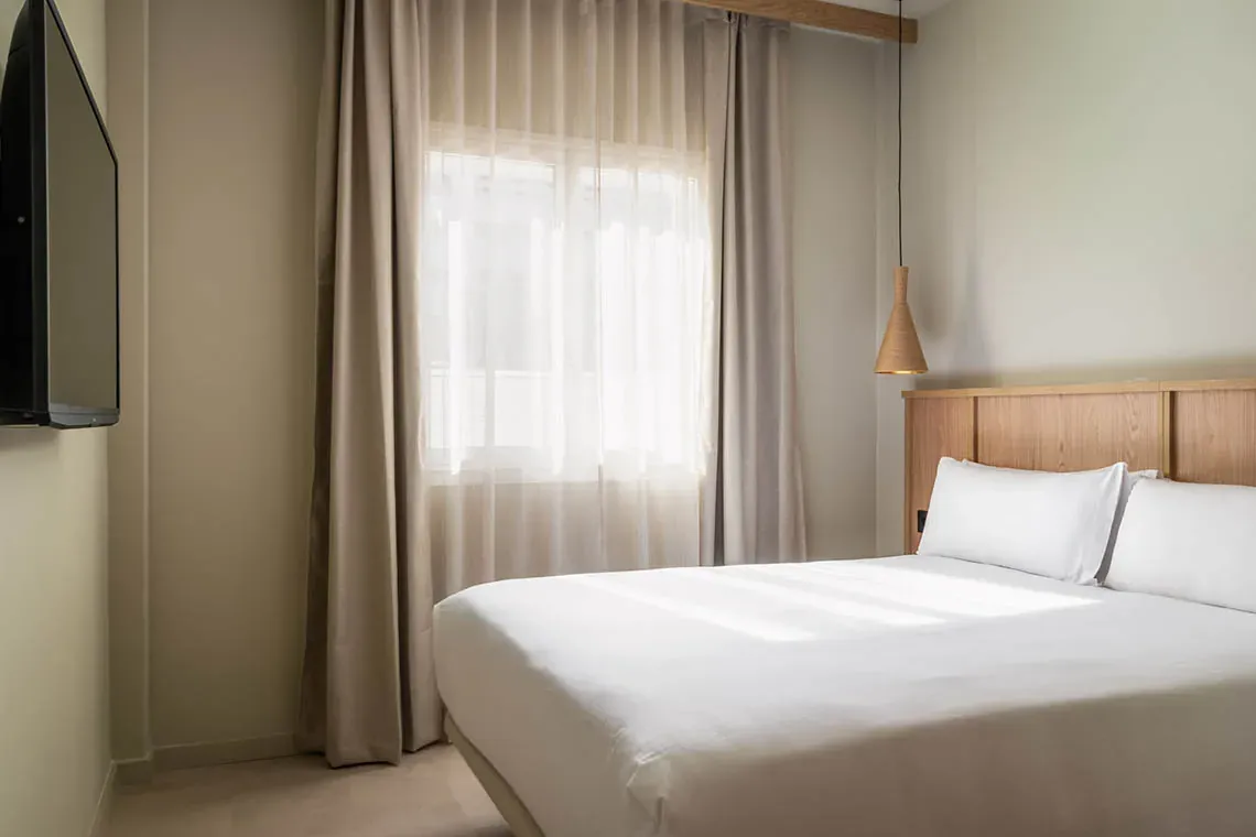 Habitació d'hotel moderna amb llit queen-size, ideal per a ESTIVAL: Corporatiu.