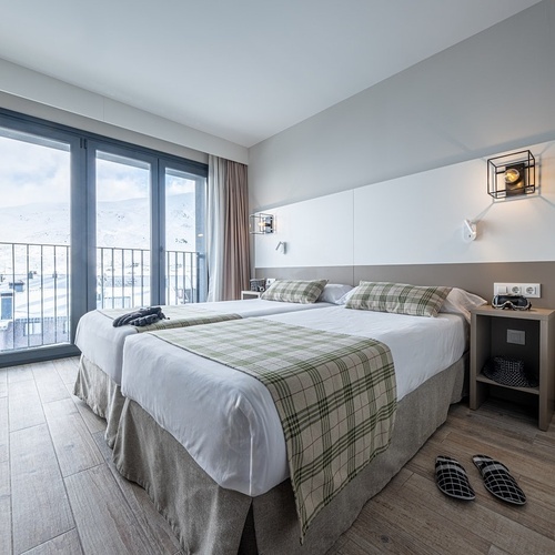 a hotel room with two beds and a balcony