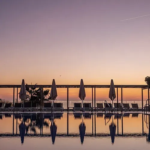 Estival Torrequebrada: Poolside loungers & umbrellas at sunset. Estival Group Official Web.
