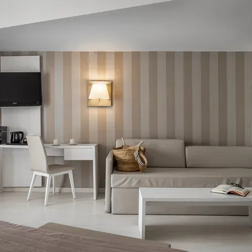 ESTIVAL: Modern room with sofa, desk, and TV.
