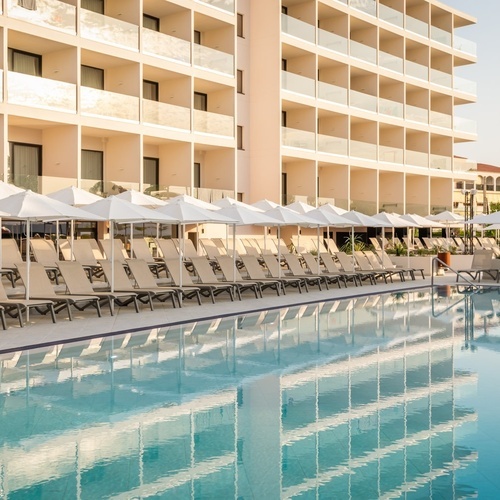 a large swimming pool surrounded by chairs and umbrellas