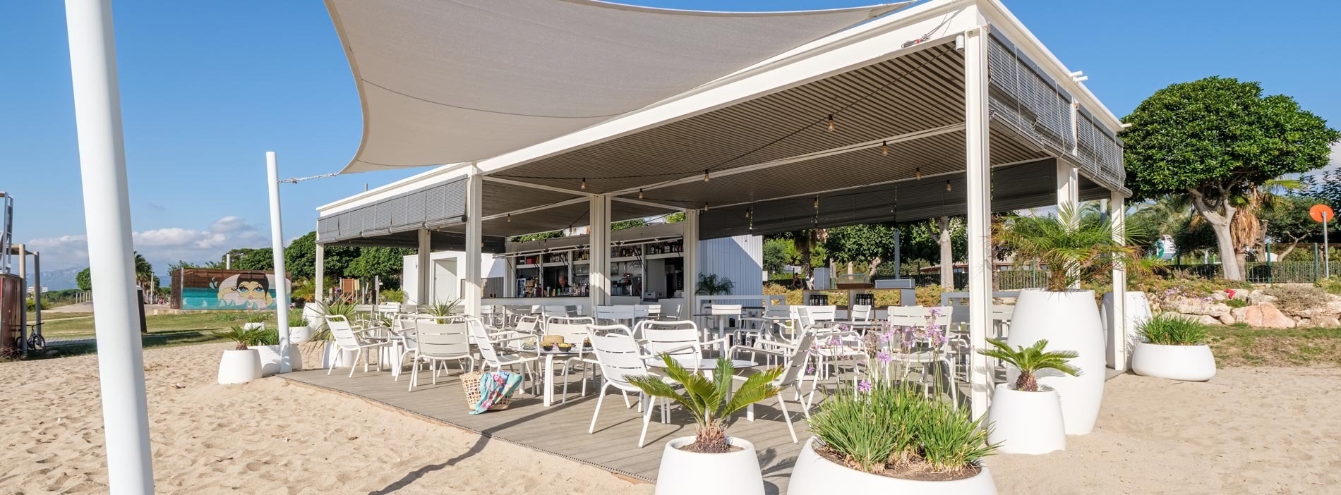 a view of the ocean from a restaurant with tables and chairs