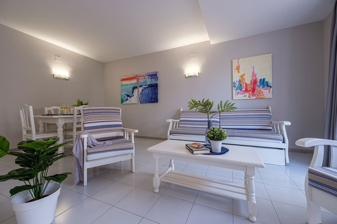 Modernes Wohnzimmer mit gestreiften Möbeln, Kunst und Pflanzen - ideal für Ihren ESTIVAL: Corporativa.