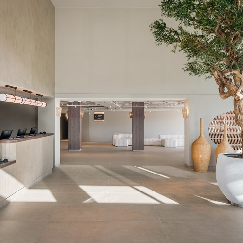 a woman stands behind a counter in a hotel lobby