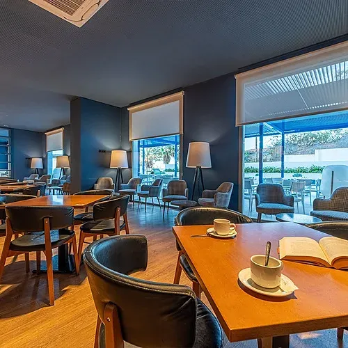 Estival Torrequebrada Benalmádena: Cozy lounge with tables, chairs, lamps, and an open book.