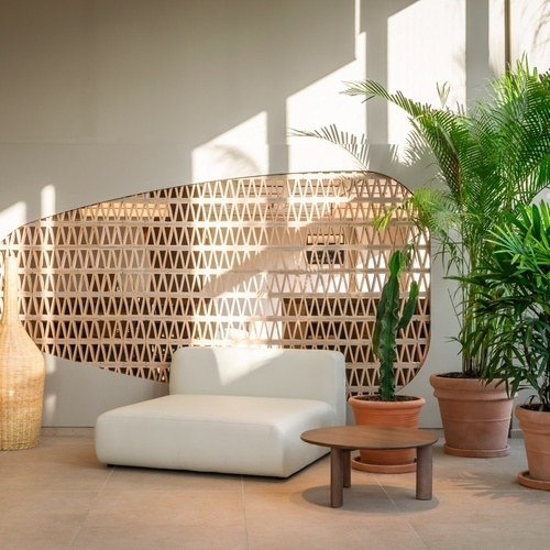 a white chair sits in front of a wall with a pattern on it