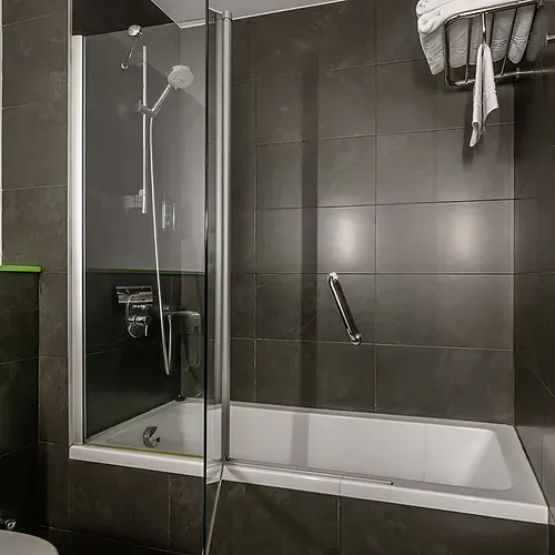 Hotel rooms with beds and teddy bear, hallway, and bathroom with towels. Hotel Sporting Andorra | Official Web.
