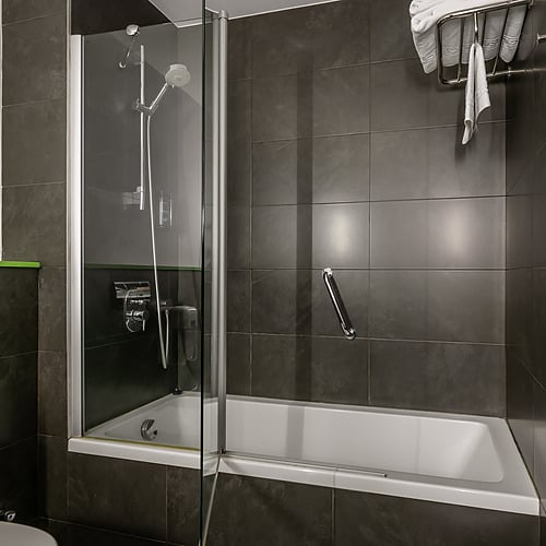 Hotel rooms with beds and teddy bear, hallway, and bathroom with towels. Hotel Sporting Andorra | Official Web.