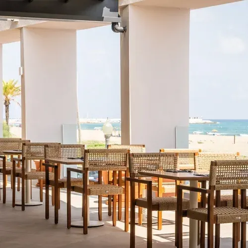 Tische und Stühle in einem Restaurant mit Blick auf den Strand