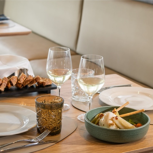 a table with plates glasses and a bowl of food
