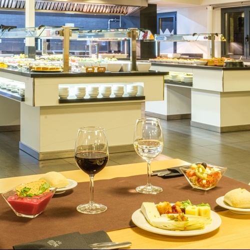 two glasses of wine sit on a table in front of a buffet