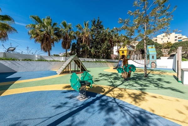 a children 's playground in front of a hotel