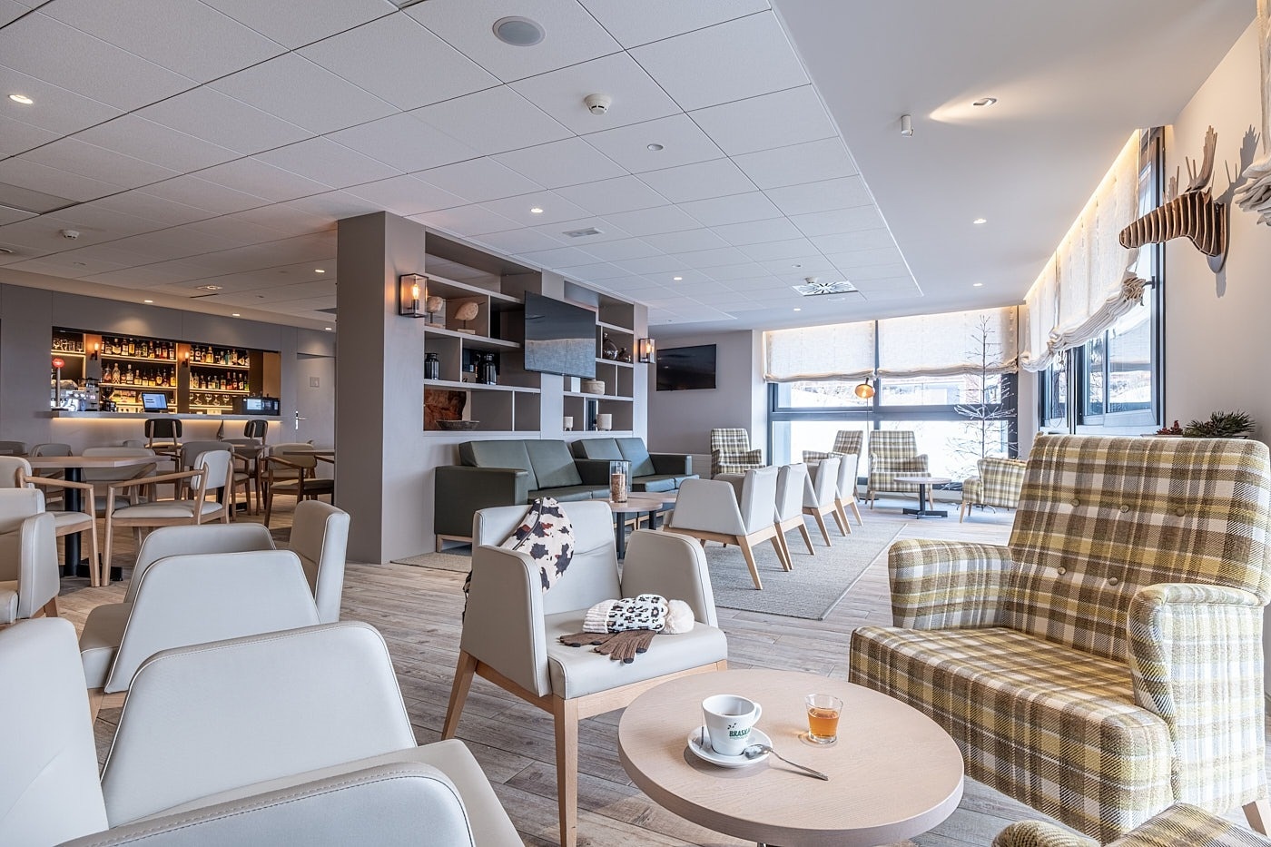 a room with tables and chairs and a tv on the wall