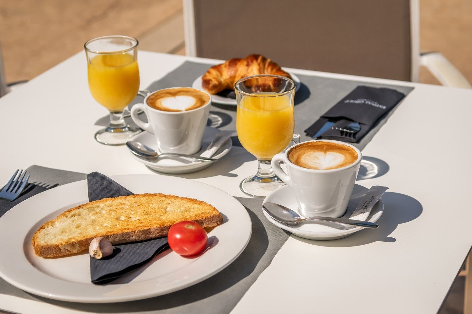 two cups of coffee and two glasses of orange juice on a table