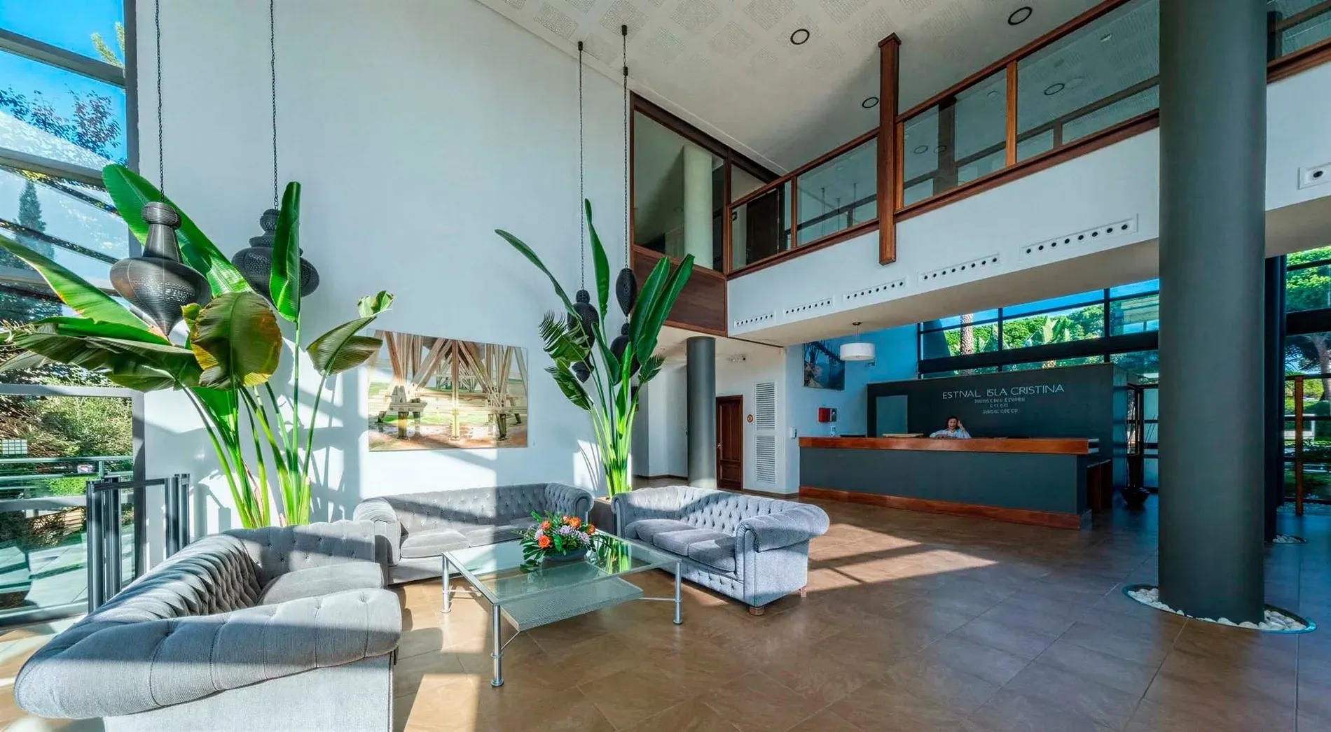 Hotel lobby with sofas, plants, and reception desk. FAQs | Estival Isla Cristina 4* Superior.
