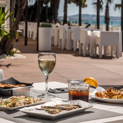 una mesa con platos de comida y un vaso de vino