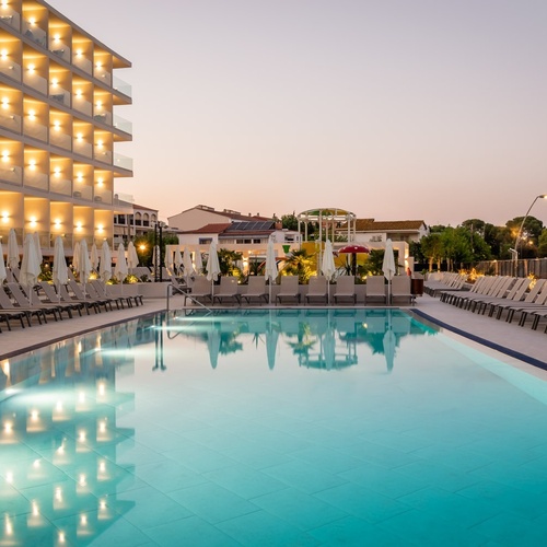 a large swimming pool surrounded by chairs and umbrellas