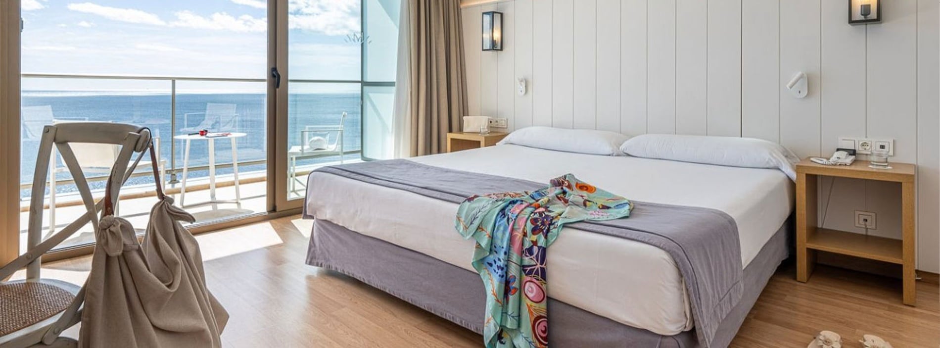 a hotel room with a balcony overlooking the ocean