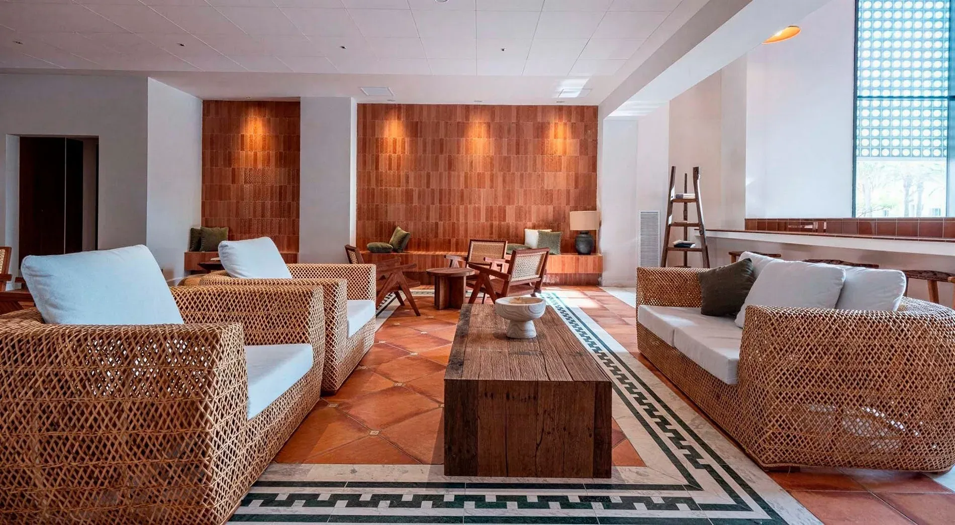 Lounge amb mobles de vímet, taula de fusta i paret de maó vist. Galeria | Hotel Estival Park Marena 4* | Tarragona