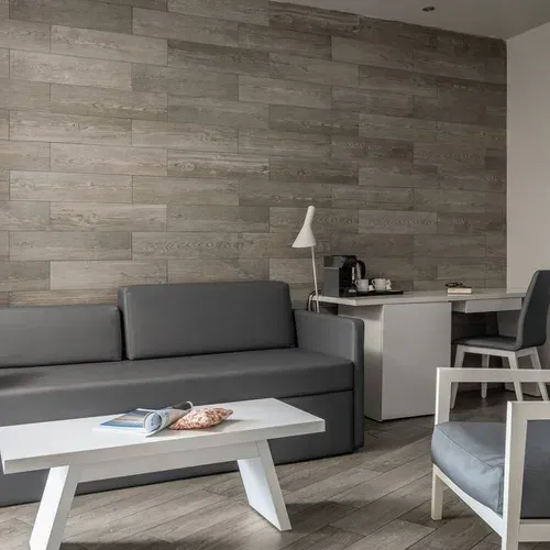 ESTIVAL Corporate: Gray sofa and desk in modern hotel room.