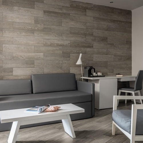 una sala de estar con un sofá gris y una mesa blanca