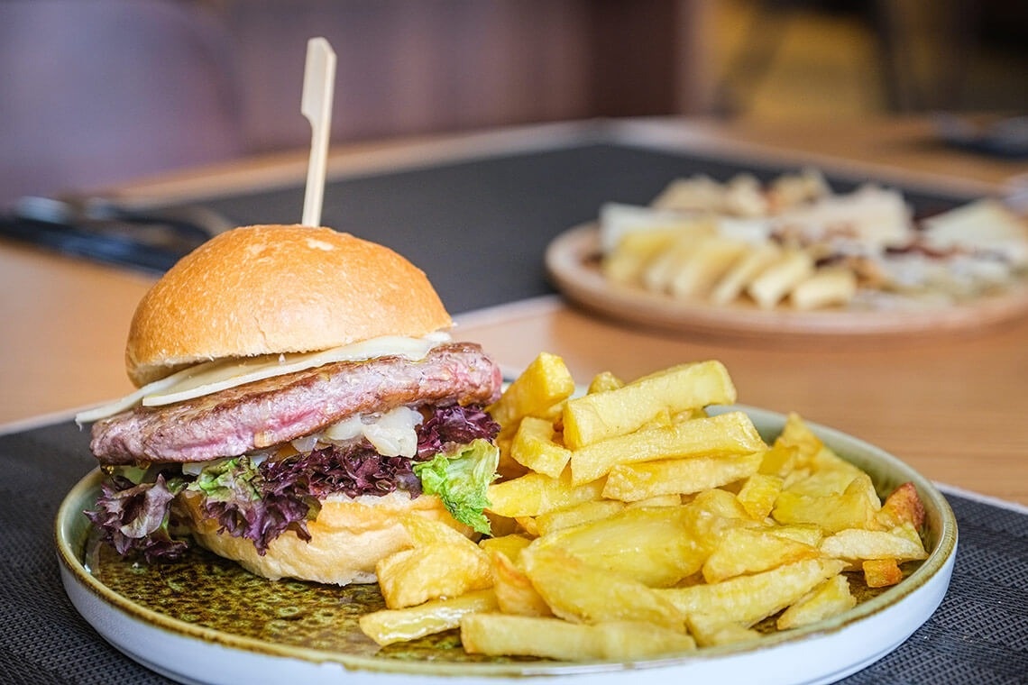una hamburguesa y papas fritas en un plato blanco