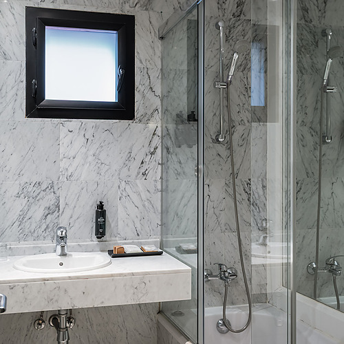 ESTIVAL: Corporativa: Modern marble bathroom with tub and sink.