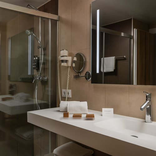 Bright hotel bathroom with shower, tub, and vanity at Estival Park Almaris, Tarragona.