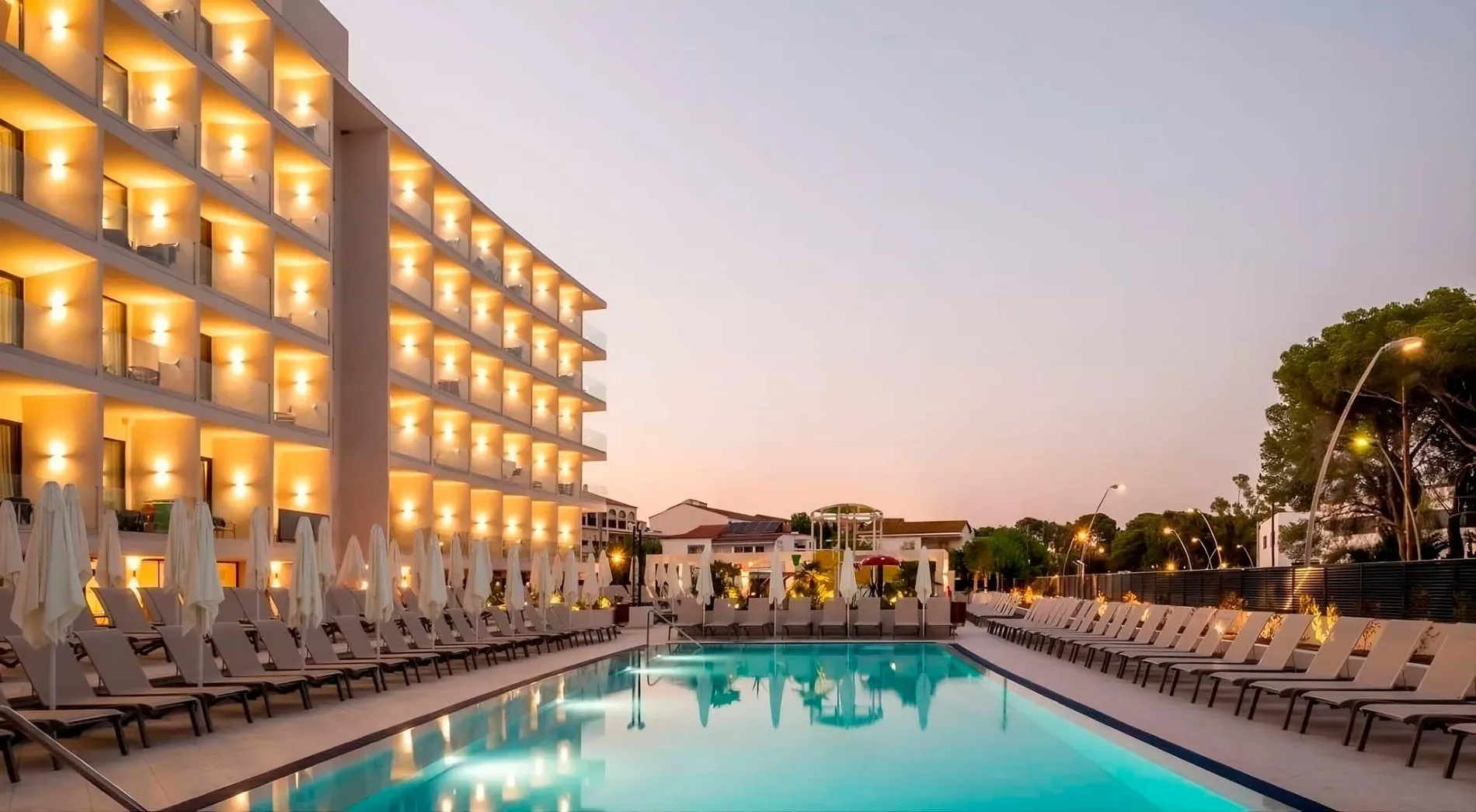 Estival Maramar: piscina con tumbonas y hotel iluminado, Estival Group, Tarragona.