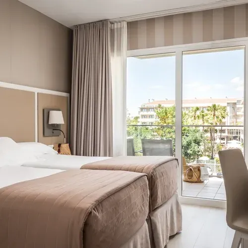 ESTIVAL Corporate: Room with two beds, balcony, and exterior view.