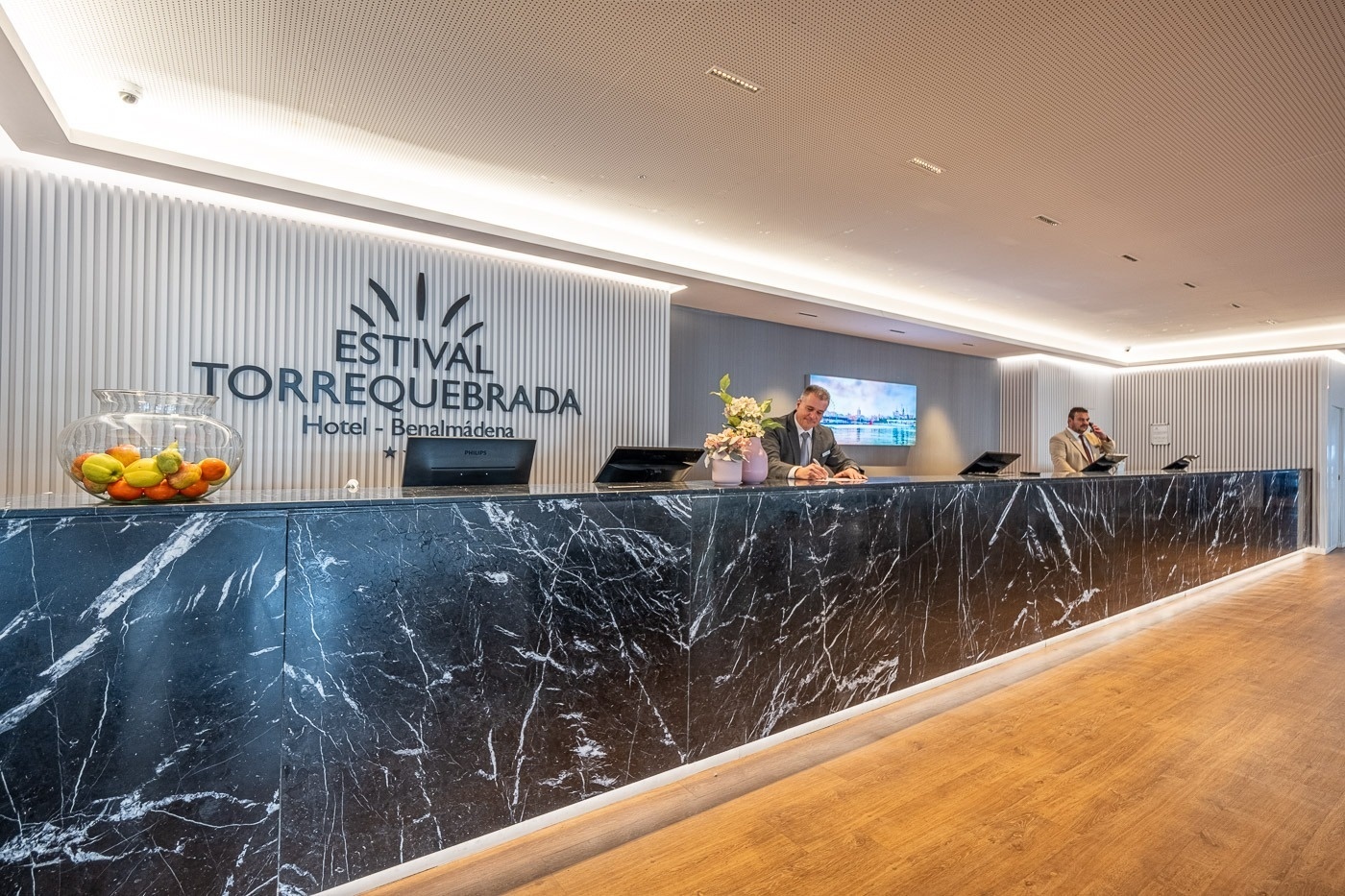 a man stands behind a counter at the estival torrequebrada hotel