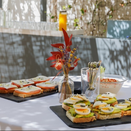 a glass of wine sits on a table while a waitress prepares food