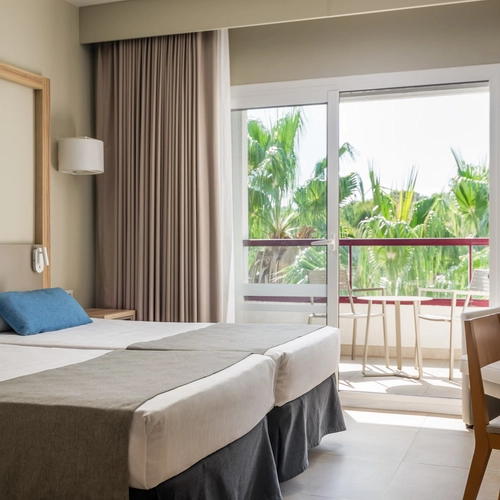 Estival Park Almaris: Modern hotel room with double bed, desk, and sofa. Official Web.