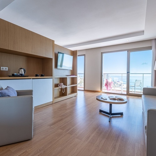 a living room with a couch and chairs and a table with a book on it