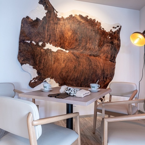 a table and chairs in front of a cowhide rug