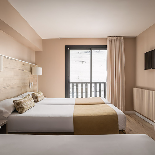 Comfortable hotel room with beds, mountain view, and TV. ESTIVAL: Corporativa