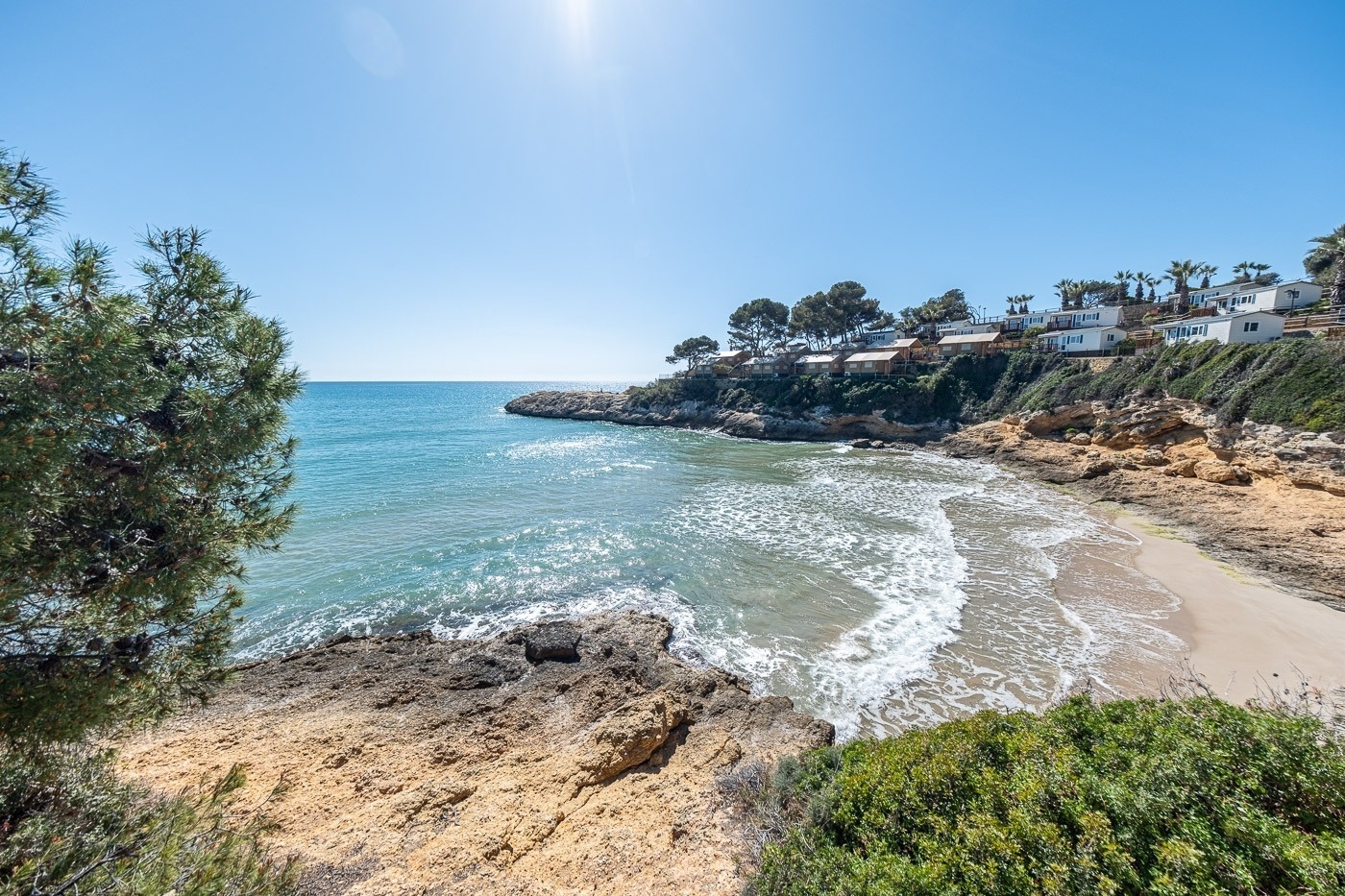 a group of houses sit on a cliff overlooking the ocean