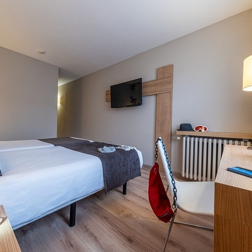 a hotel room with two beds and a skier on the wall