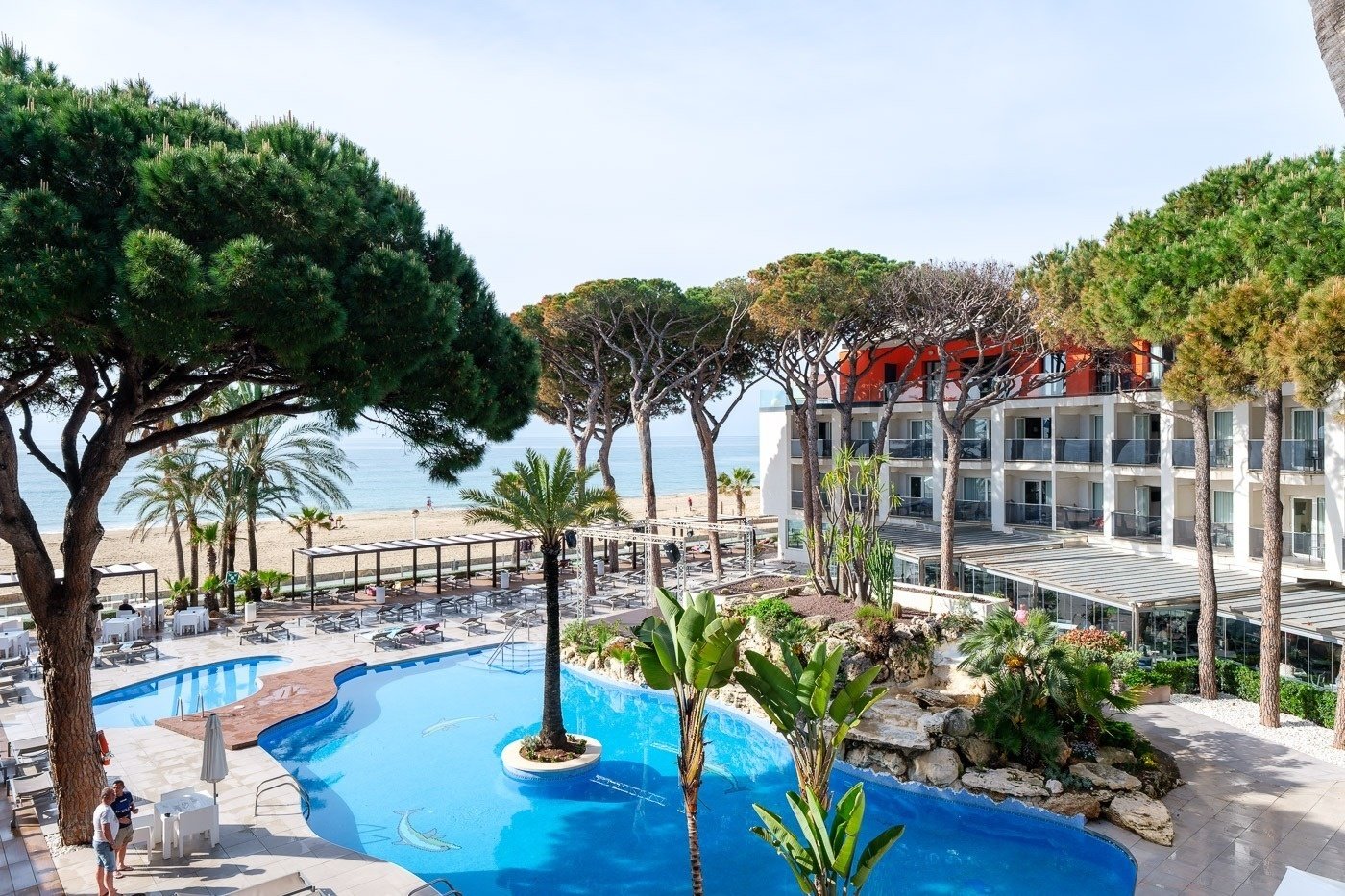 una piscina rodeada de árboles y palmeras en un resort
