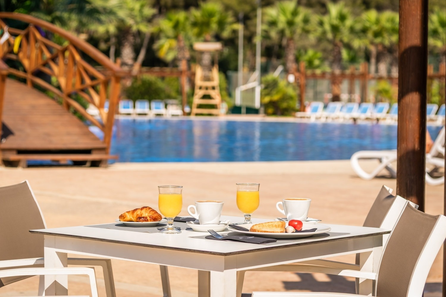 a table with a plate of food and two glasses of orange juice