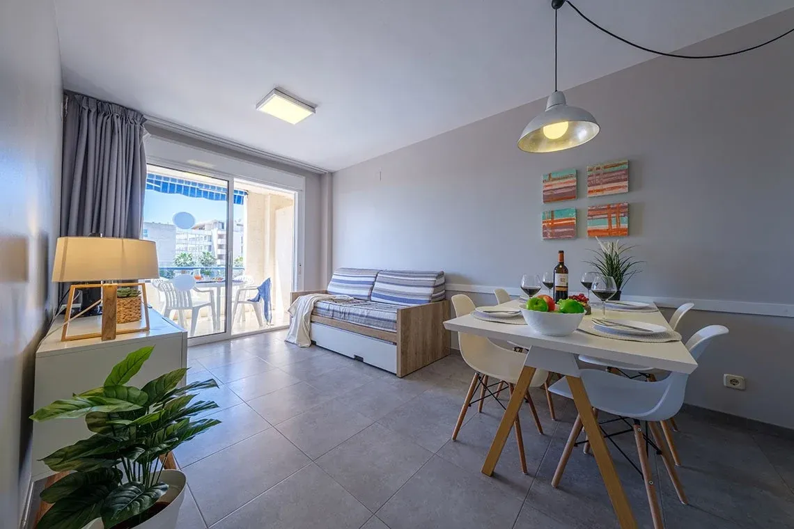 Gemütliches Wohnzimmer mit Essbereich, Schlafsofa und Balkonblick. ESTIVAL: Corporativa