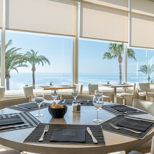 a restaurant with a view of the ocean and palm trees