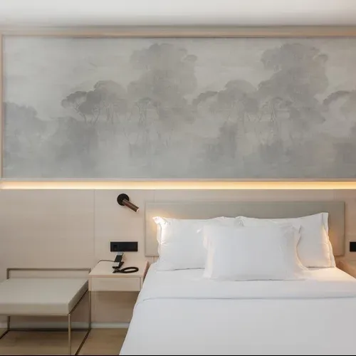 Hotel Vilamari Barcelona: modern bedroom with serene landscape mural and warm lighting.